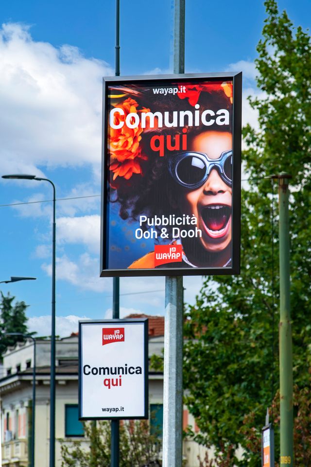 Pubblicità affissione su strada nel centro di Milano su pali luce