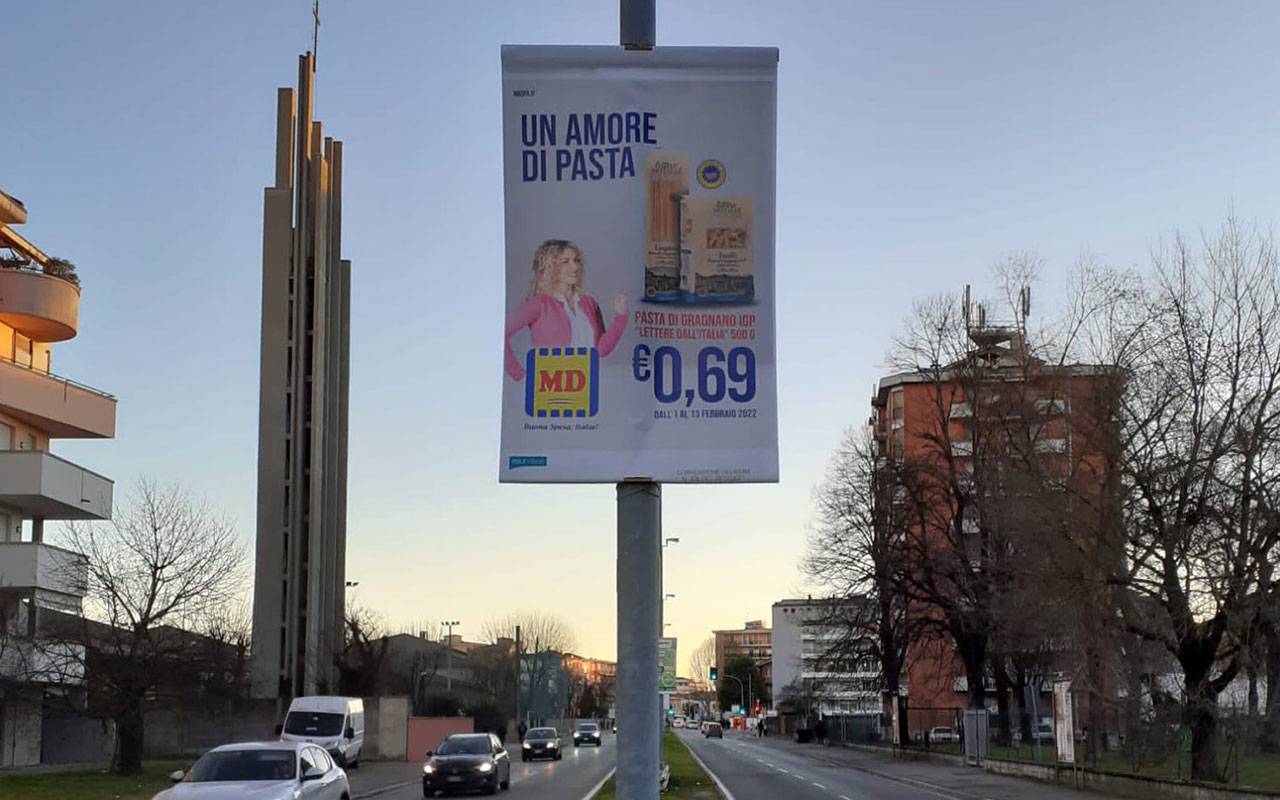 Cartelli pubblicitari a noleggio su pali della luce a Lodi con prodotto, prezzo e nome del punto vendita